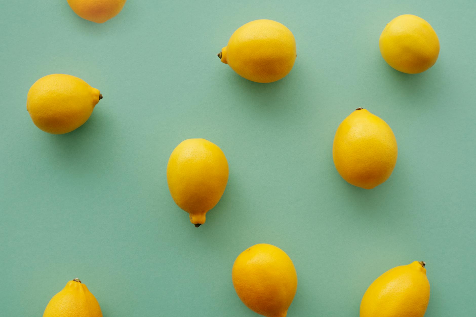 Bright yellow lemons on a pastel green background, symbolizing fresh sexuality and personal pleasure