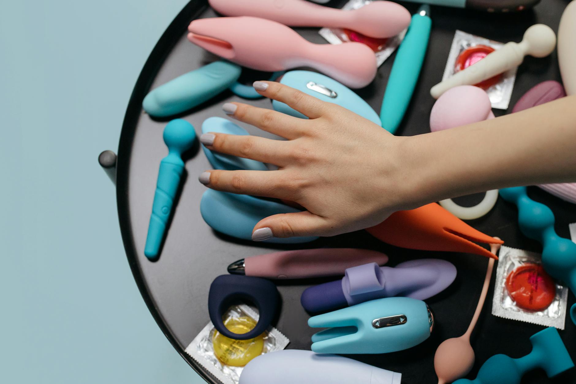 Close-up of hands holding a blue personal massager against a knitted sweater.