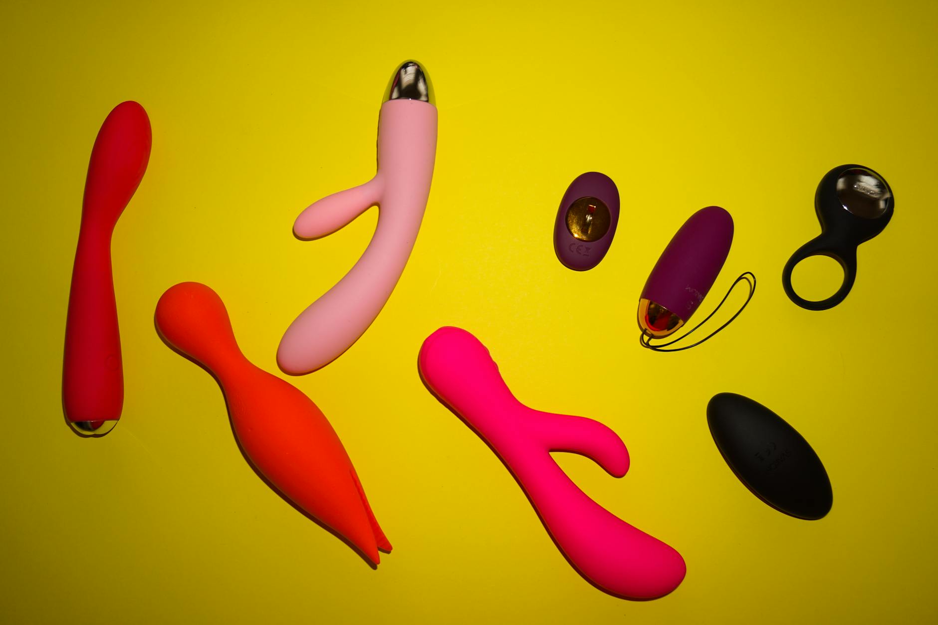 Colorful lemon vibrators and adult toys displayed on a bright yellow surface