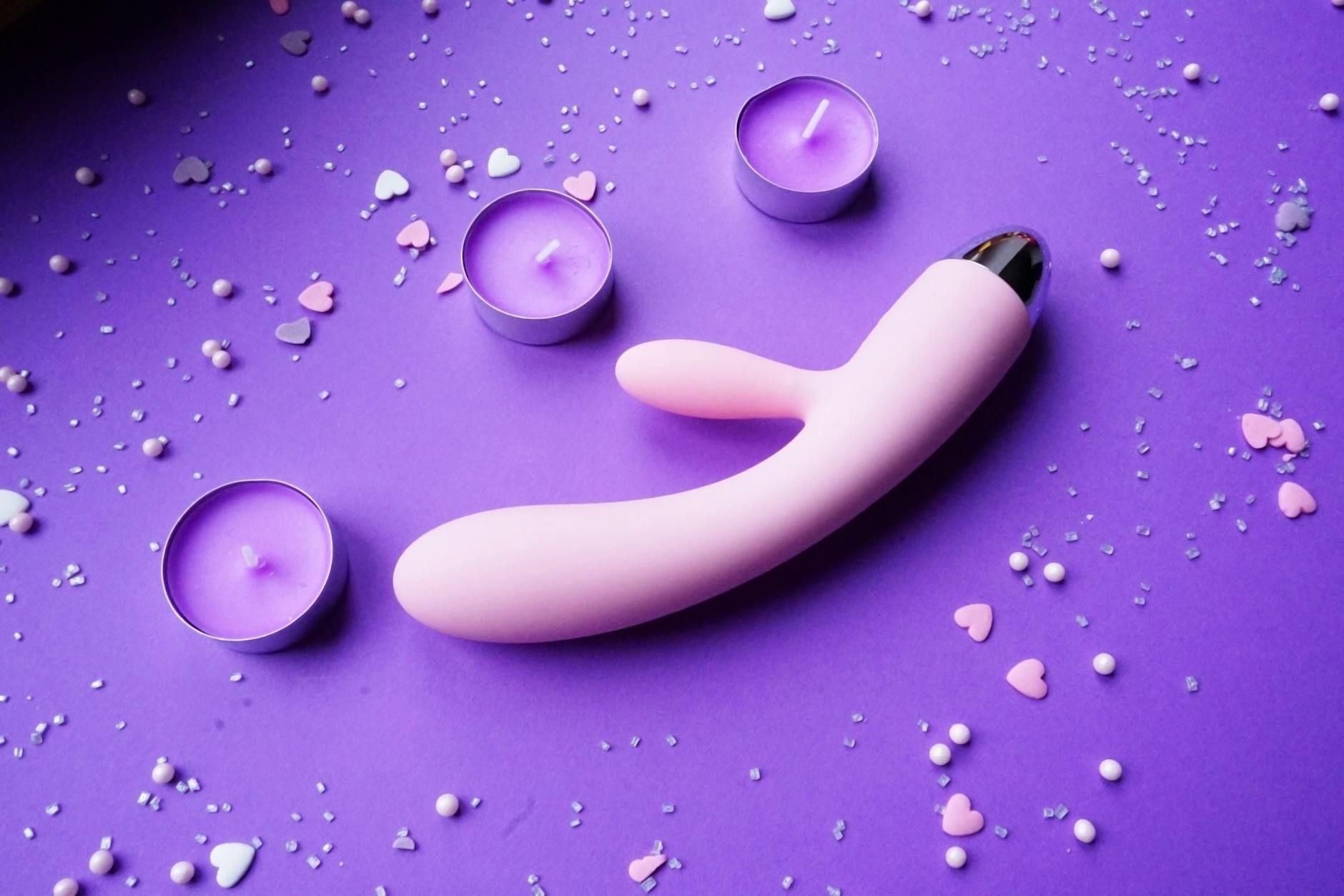 Yellow lemon vibrator surrounded by fresh lemons on a bright background