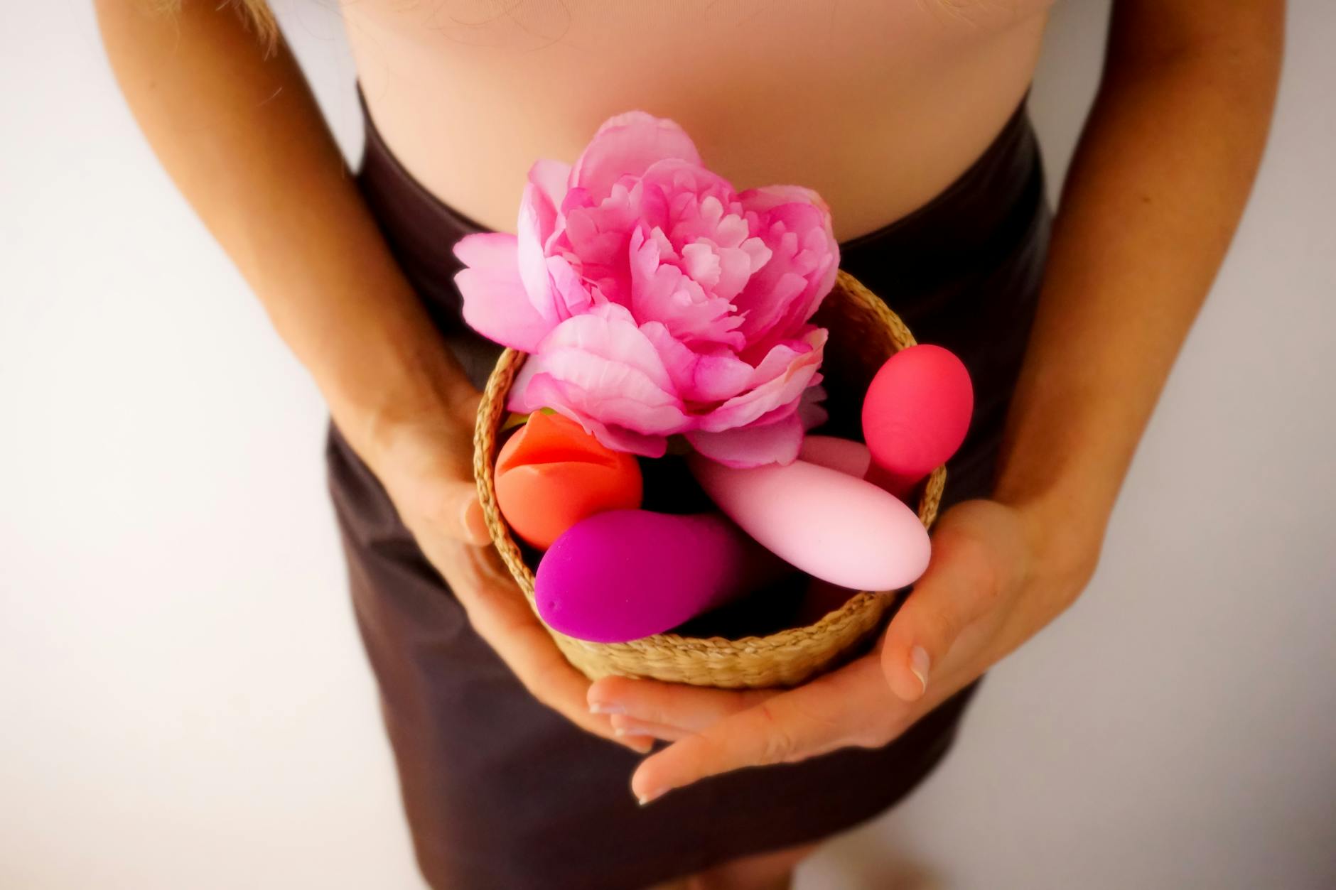 Close-up of colorful vibrators including air-pulse clitoral stimulators arranged on a neutral surface
